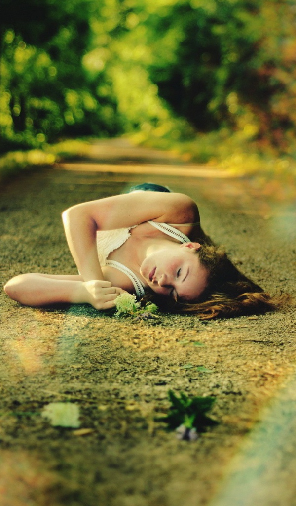 Женщина спит на лесной дороге