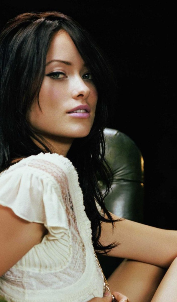 Модель брюнетка на зеленом кожаном кресле