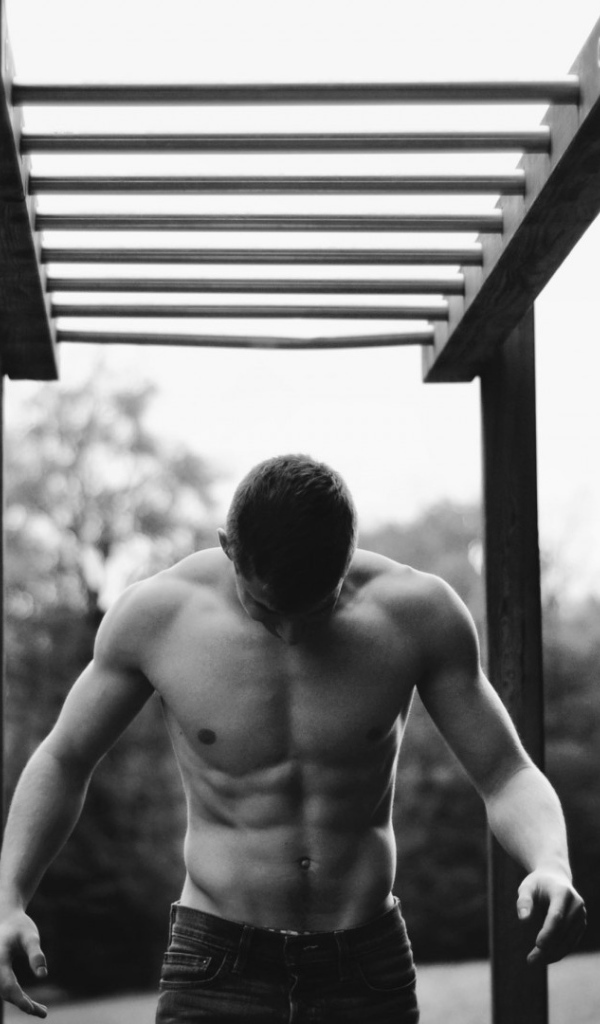 Мужчина занимается спортом на турнике