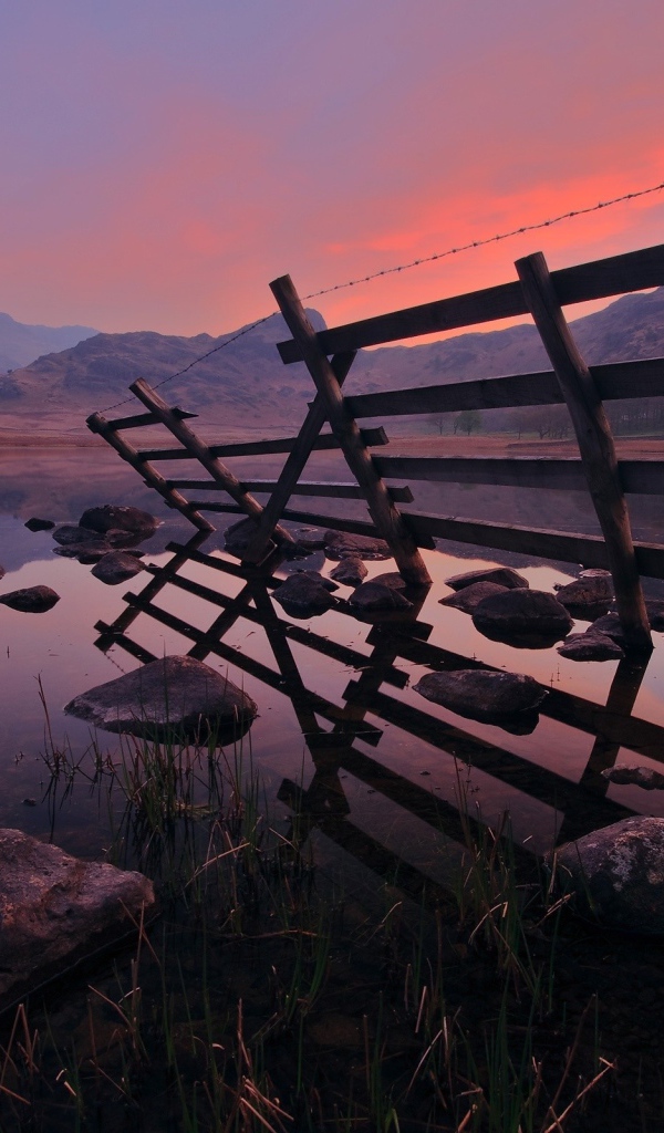 Полуразрушенный забор у воды