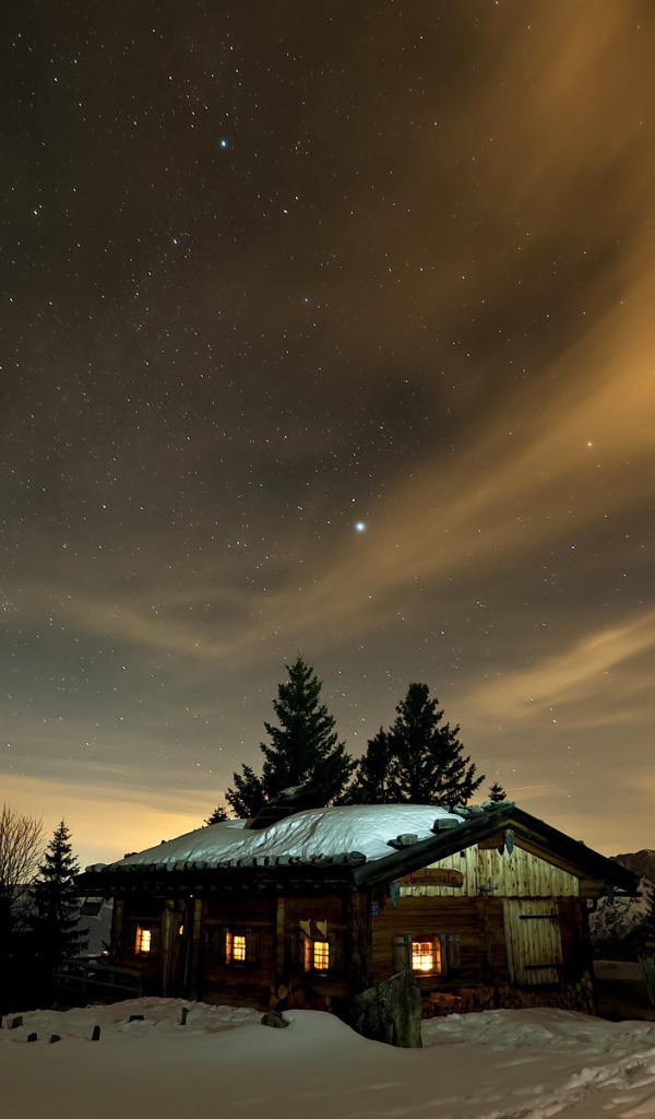 Северное сияние в небе над деревянной избушкой