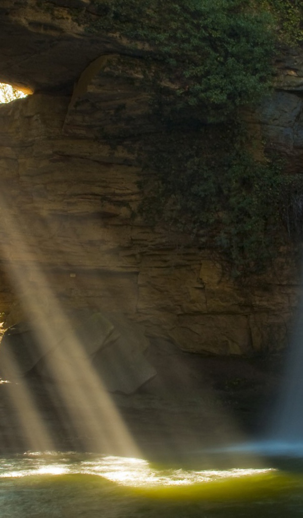 Лучи солнца и вода падают в пещеру