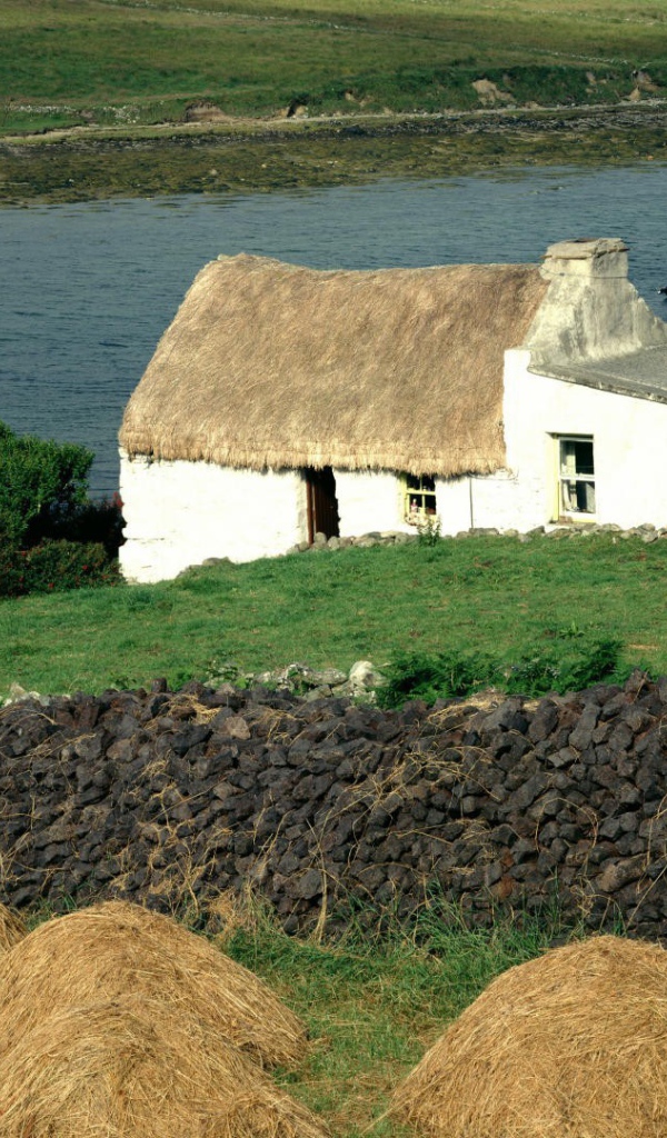 Покрытый соломой дом на берегу реки