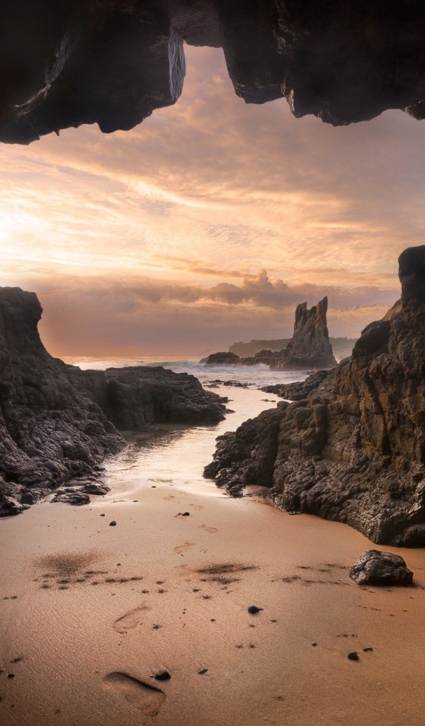 Мокрый песок у входа в пещеру