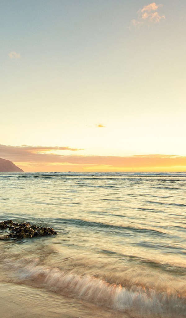 Волны прибоя накатывают на пляж