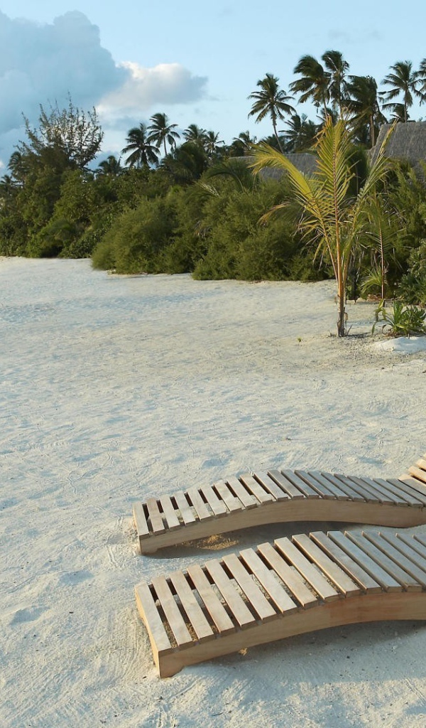 Деревянные шезлонги на белом песке пляжа
