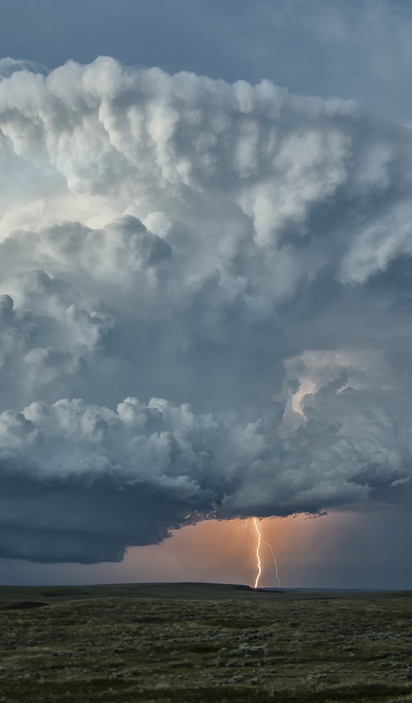 Оранжевая молния в огромном белом облаке