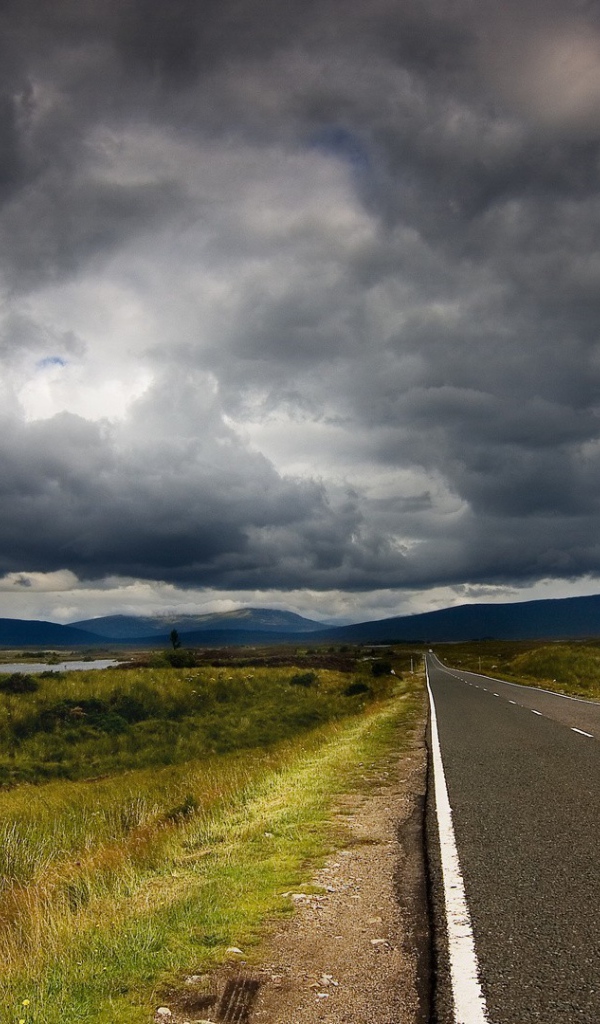 Шоссе среди полей под мрачными облаками