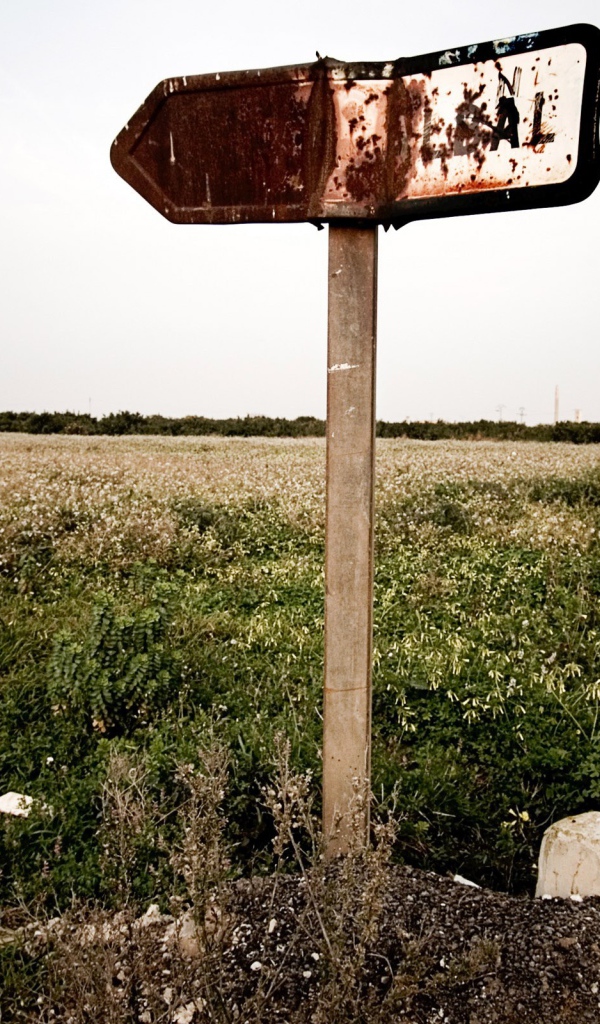 Ржавый указатель направления у поля