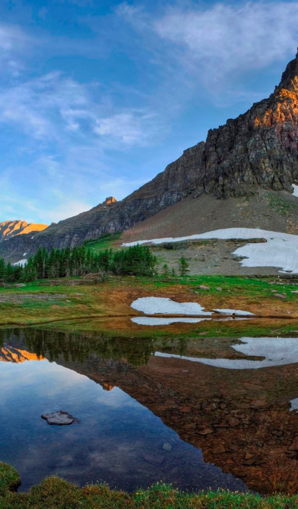 Небольшая гора отражается в спокойной реке