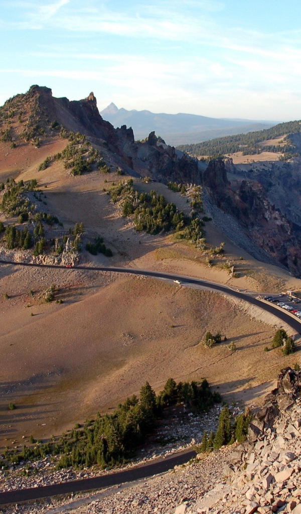 Шоссе огибает скалы у озера в горах