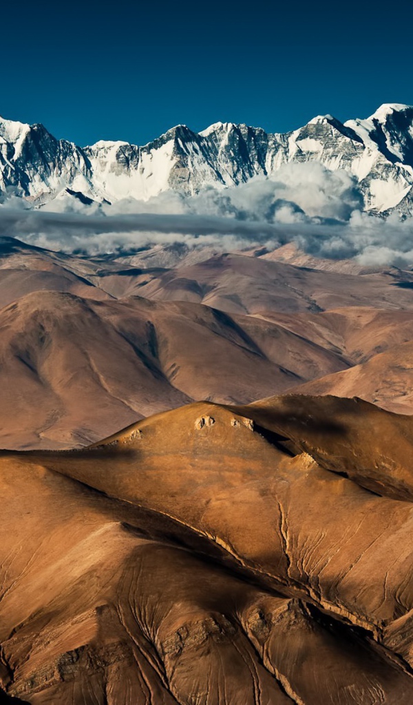 Покрытые снегом вершины высоких гор над плоскогорьем