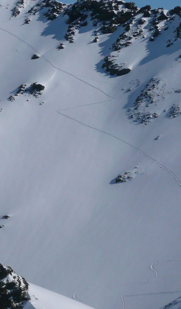 Следы лыжников на горном склоне