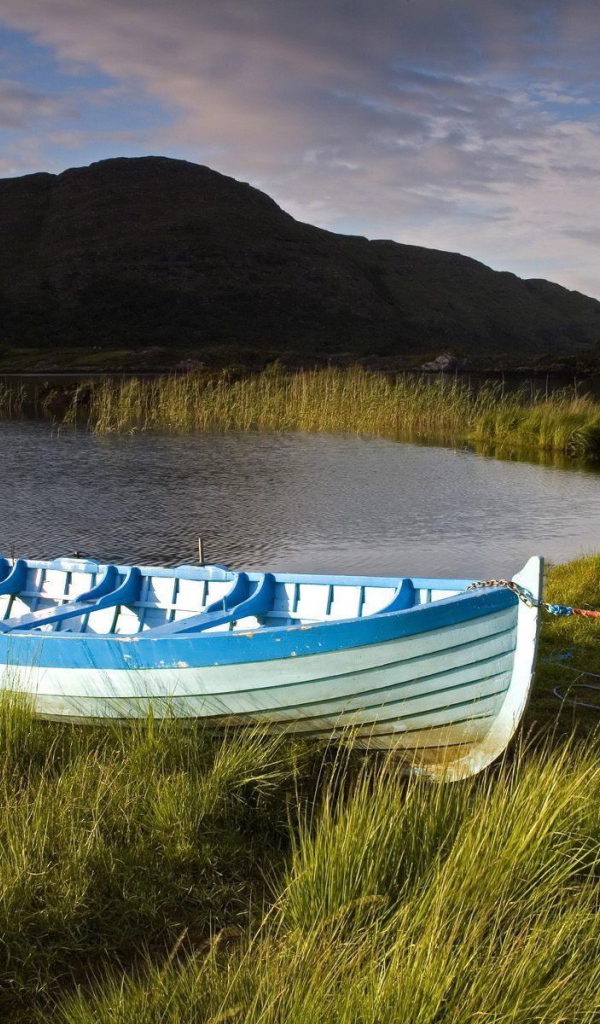 Синяя лодка на берегу озера