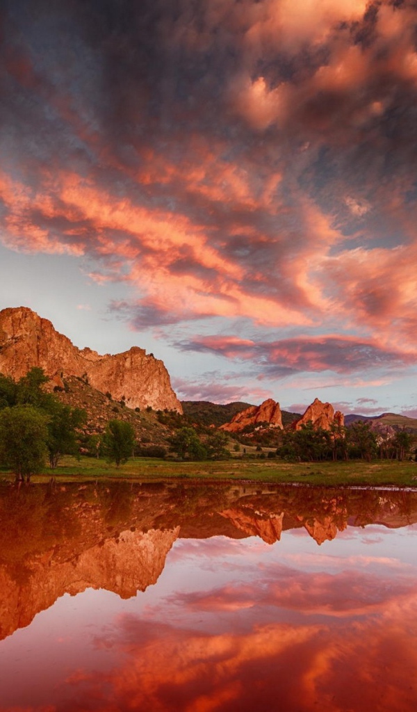 Облака отражаются в коричневой воде озера