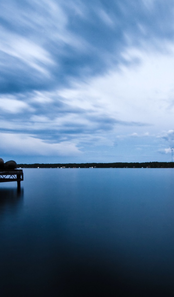 Силуэт человека на пристани у озера