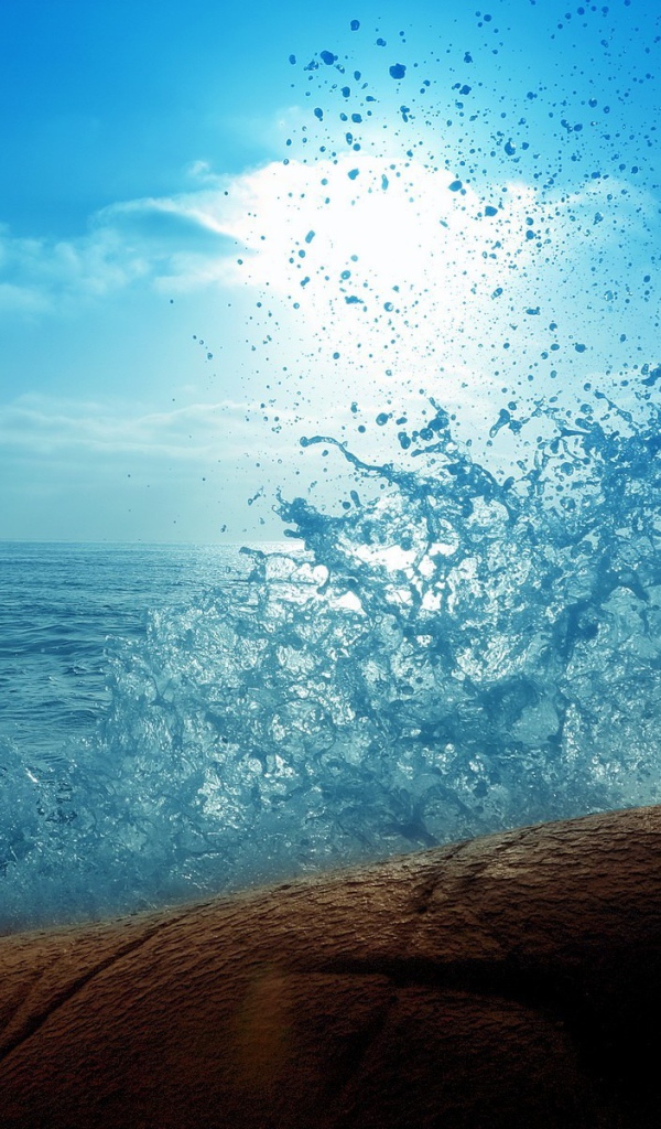 Голубая волна разбилась о камень на берегу