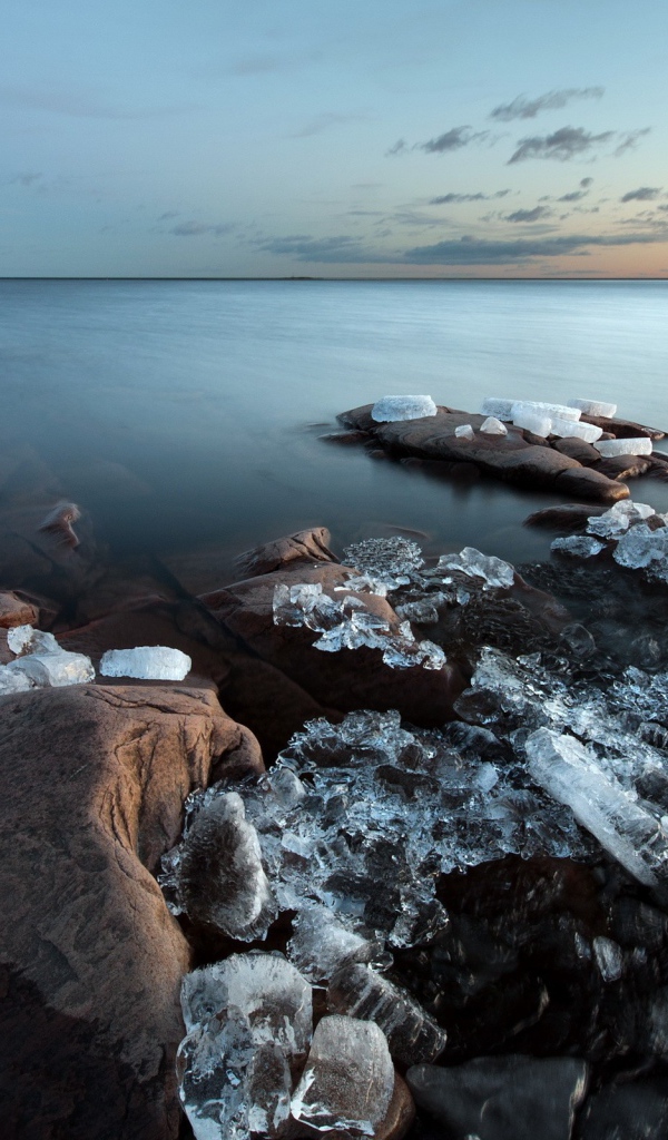 Куски льда на камнях у берега