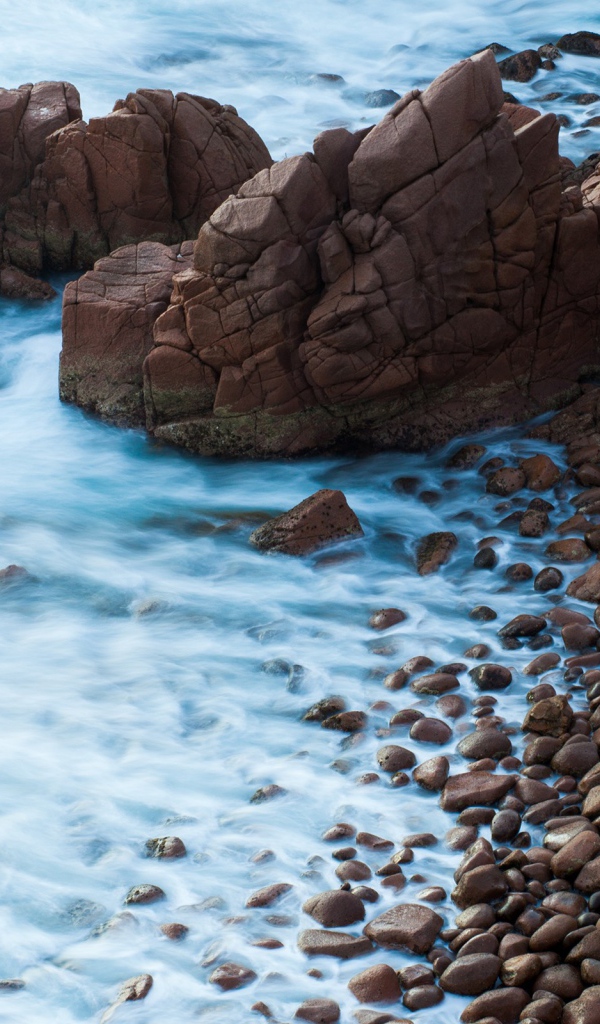 Мелкие коричневые камни на берегу моря