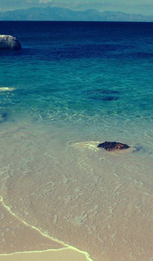 Камни в синей воде у берега моря