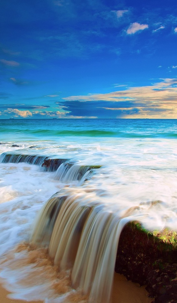 Волна прибоя накатывает на прибрежные камни