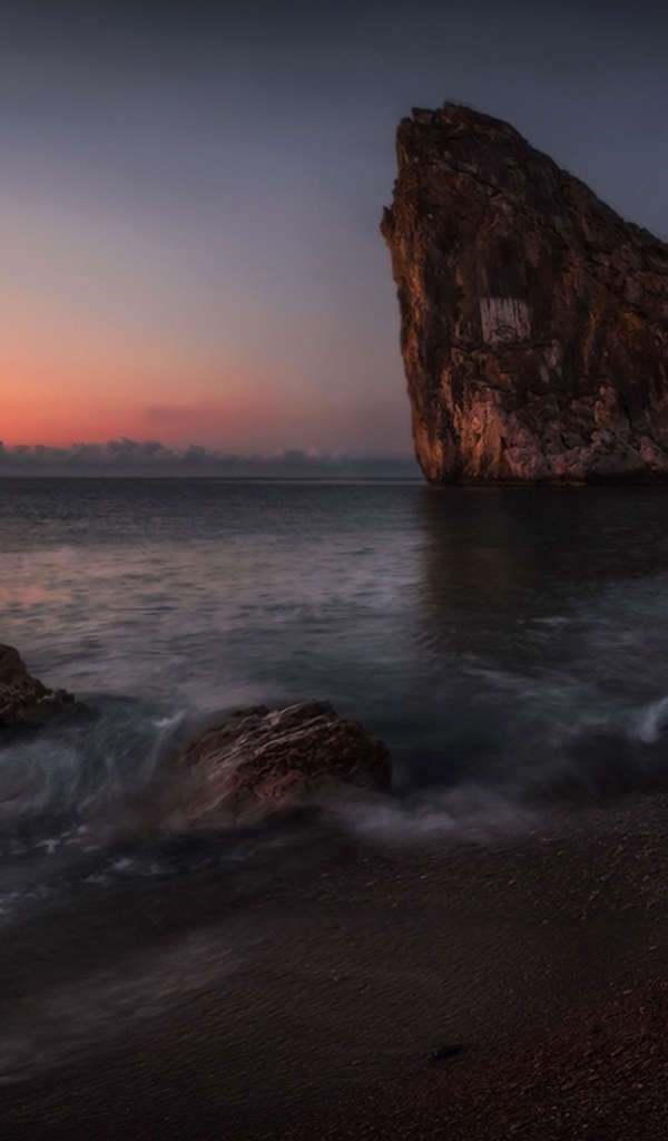 Треугольная скала на берегу моря