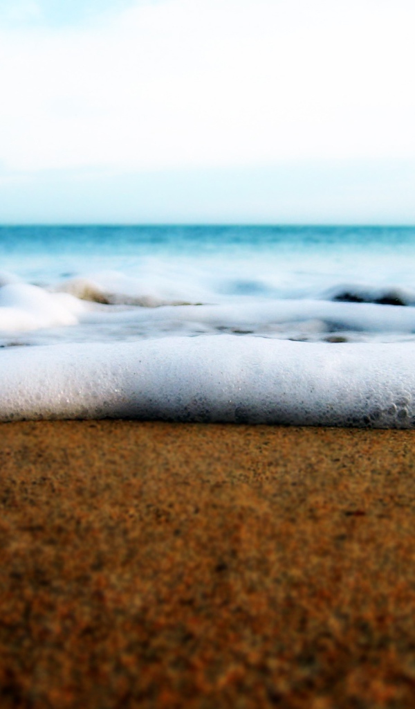 Белая пена волны у берега