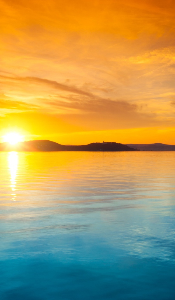 Оранжевое небо над голубой водой на закате