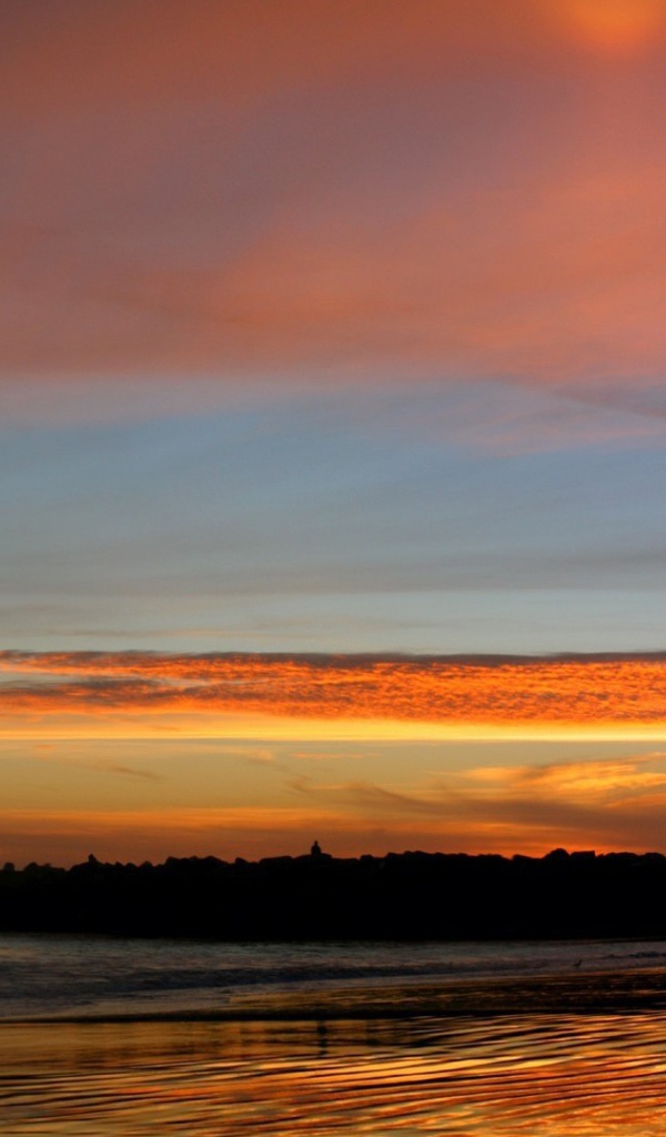 Силуэт маяка на фоне оранжевых облаков