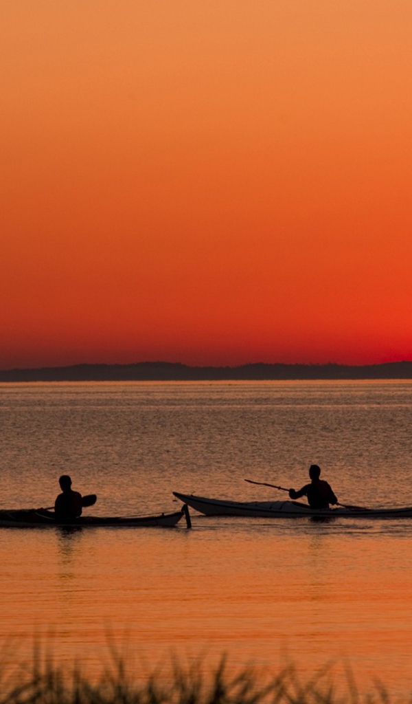 Два лодочника на фоне заката