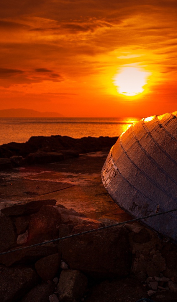 Перевернутая лодка на фоне заката