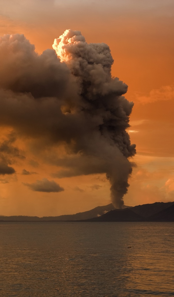 The eruption of a volcano on an island in the sea