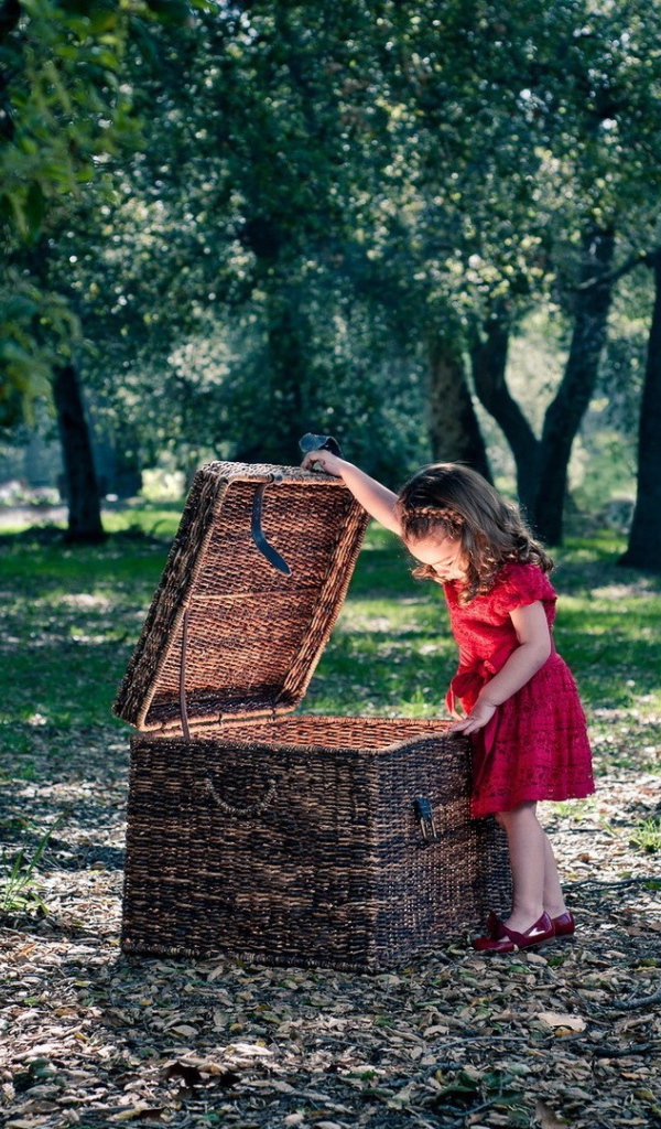 Девочка заглядывает в плетеную корзину