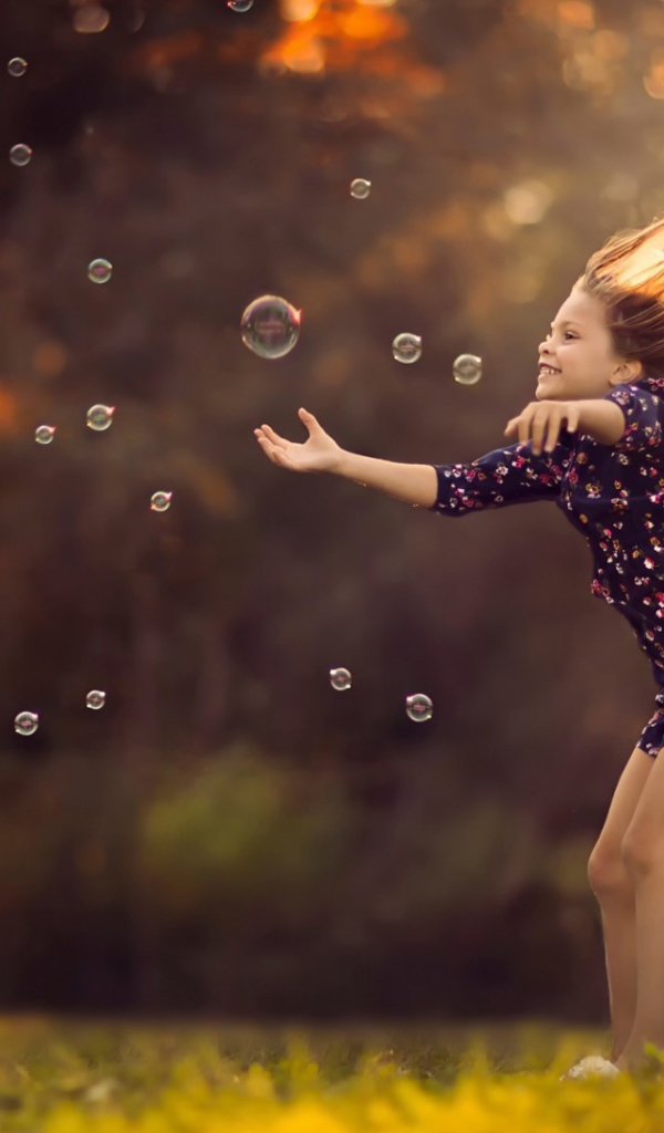 Девочка играет с мыльными пузырями