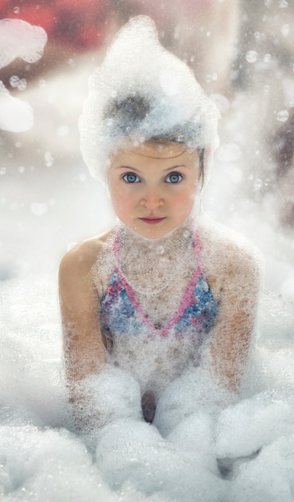 Девочка играет в пене