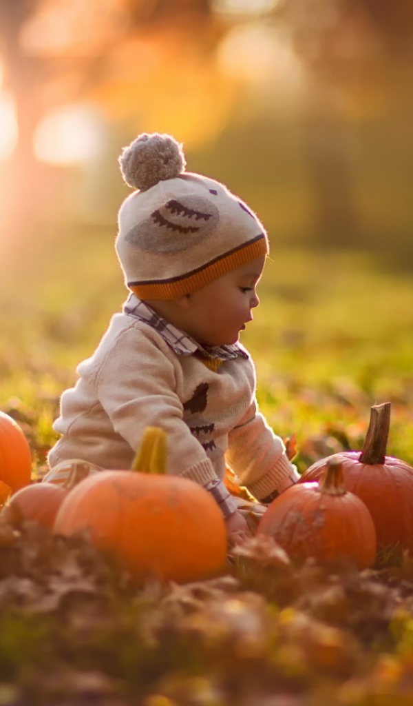 Девочка играет с тыквами