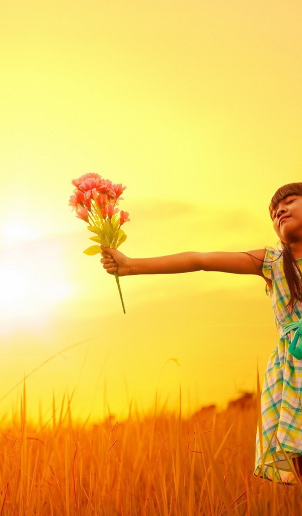 Девочка с букетом стоит в поле
