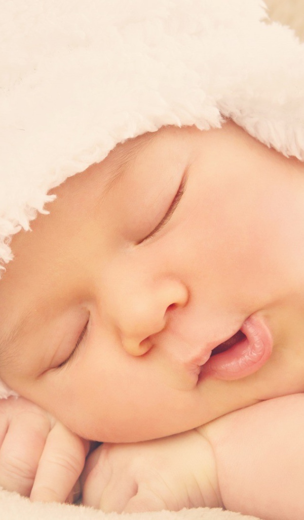 Спящий ребенок в белой шапке