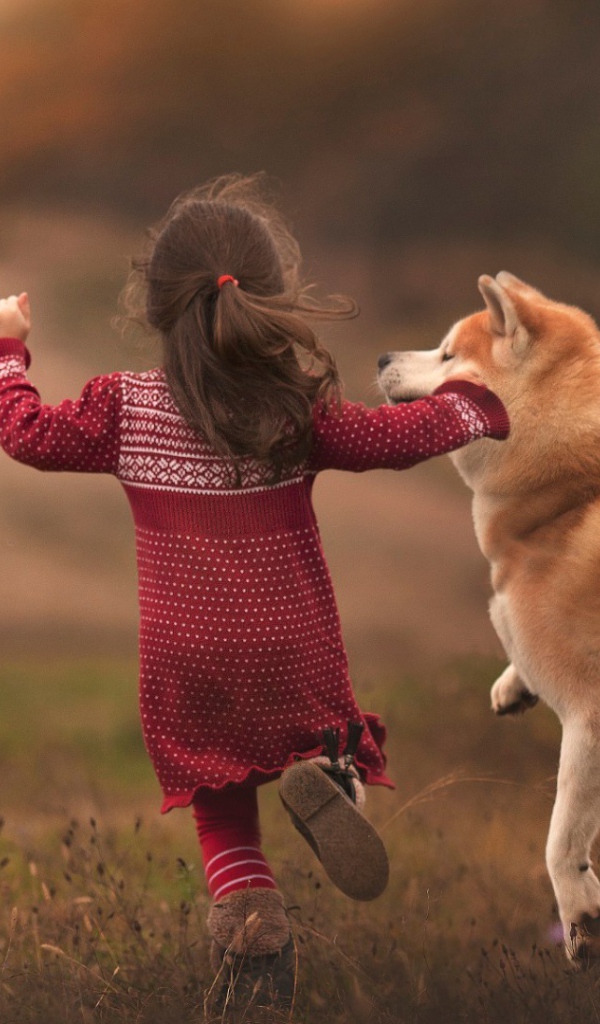 Девочка бежит по полю с собакой
