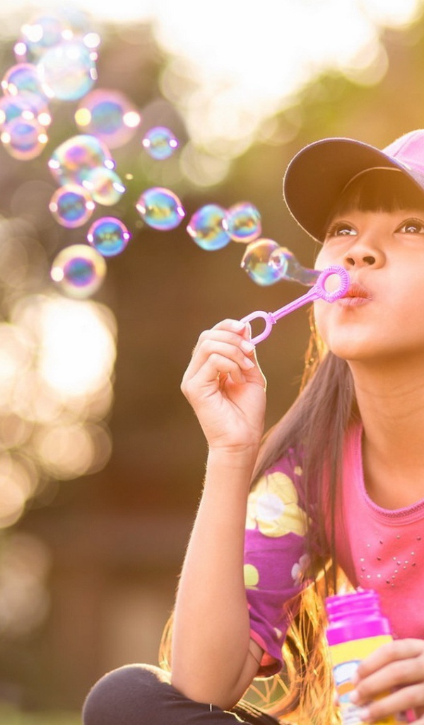 Девочка запускает мыльные пузыри