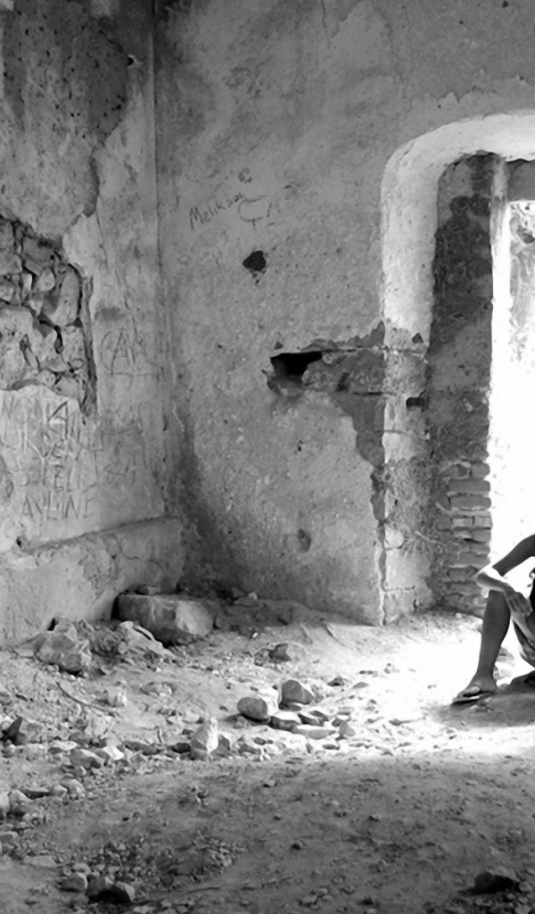 Человек на развалинах дома