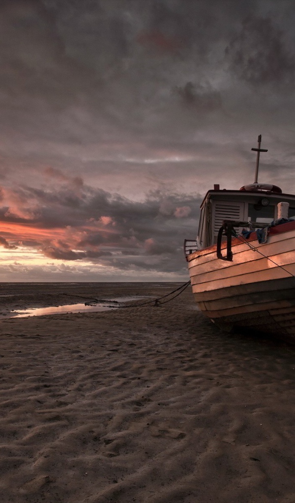 Лодка на песке пляжа во время отлива