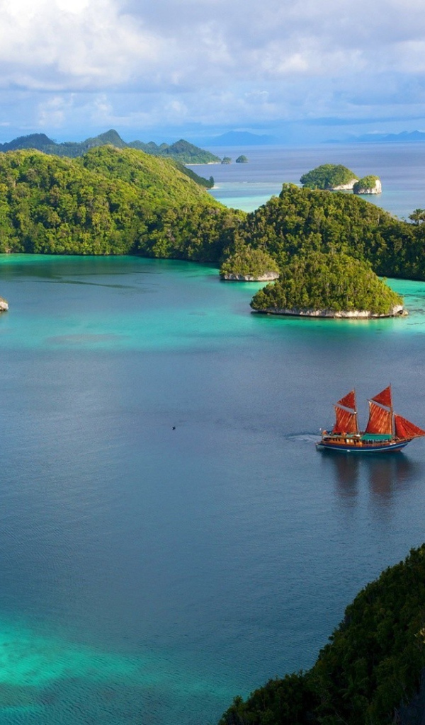 Корабль с красными парусами среди островов