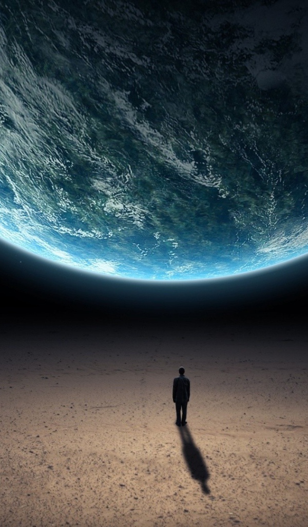 Человек стоит перед планетой