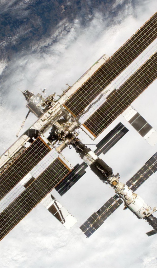 МКС пролетает над облаками на Земле