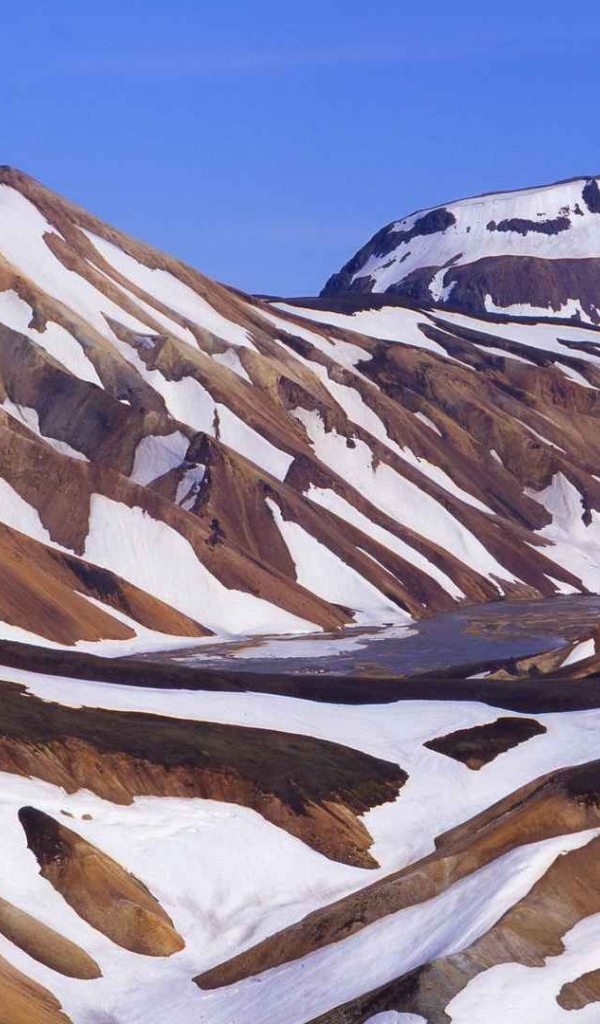 Коричневые горы в снегу в Исландии