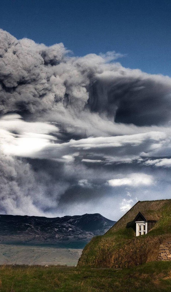 Дом в Исландии на фоне извергающегося вулкана