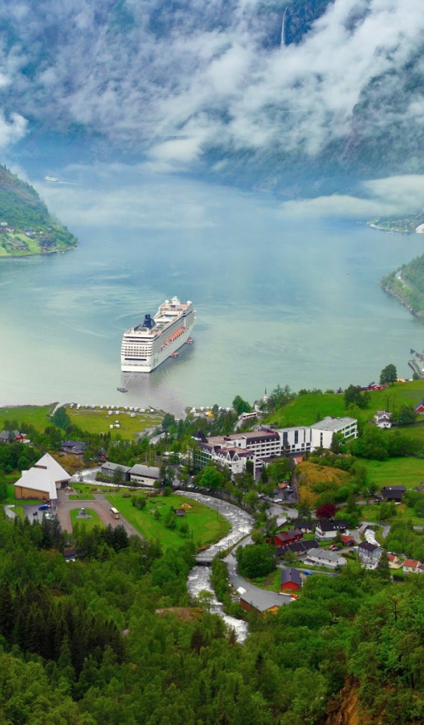 Круизный корабль у прибрежной деревушки в Норвегии