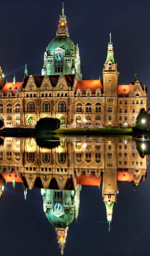 Освещенный замок с часами на башне