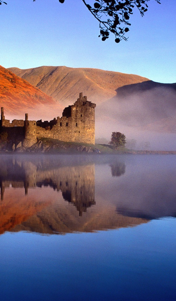 Руины замка на берегу туманного озера